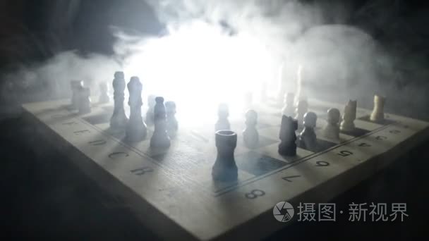 国际象棋棋盘游戏概念经营思路和竞争与战略思想概念。黑色背景与烟和雾的国际象棋棋子。选择性的焦点