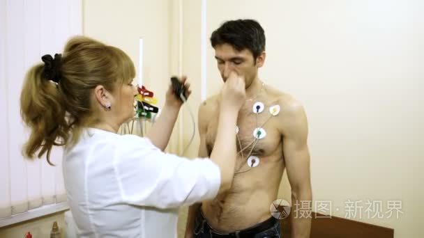 动态心电图监测装置。女医生将电极在患者胸部上的附加到日常监测心电图。高清