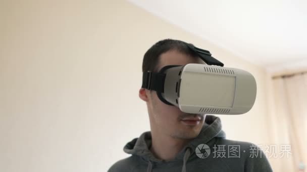 男人带着虚拟现实耳机在客厅视频