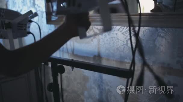 男性手固定照明设备建设的特写视图。男人握阶段光投影仪