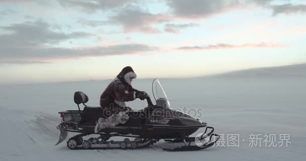 在传统的北极驯鹿外套在冰冻的湖面上驾驶雪地车旅游。亚马尔远征 2016年。在红色史诗慢动作拍摄。高清