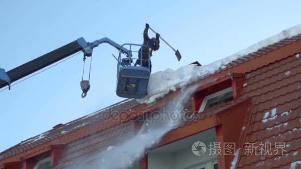 除雪的建筑物屋顶上的工人视频