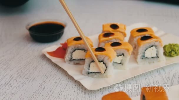 美味的寿司与三文鱼 乳酪 芥末 粉红色姜，酱油，带木枝时尚白色木制背景上