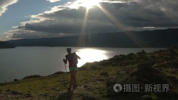 背包走圆山与湖的年轻女子