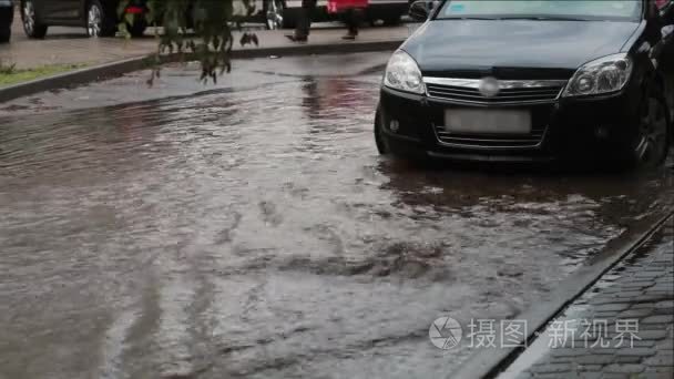 声场大雨后洪水在路面上的水。车就在附近，人走路