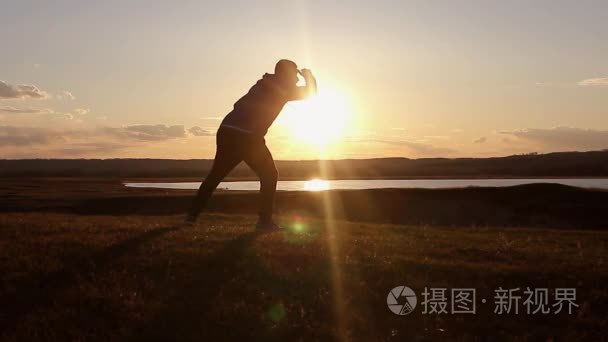 在夏天的草原上，夕阳的路人。在山顶上，年轻人的剪影