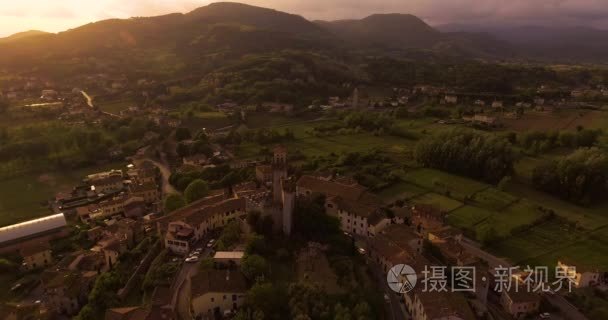 空中拍摄，在夕阳的光在意大利，4 k 山上的小托斯卡纳哈姆雷特 Nozzano 城堡