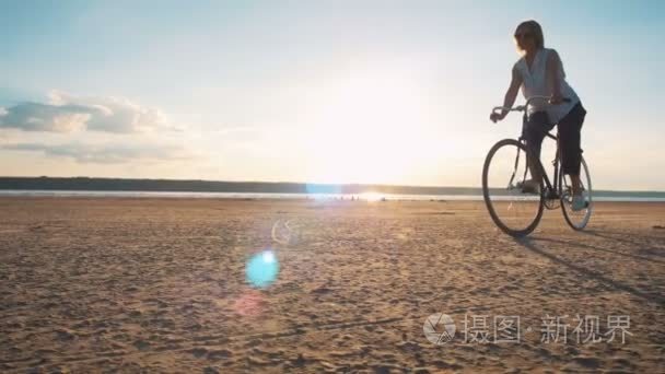 在海岸上的时髦女孩骑自行车视频
