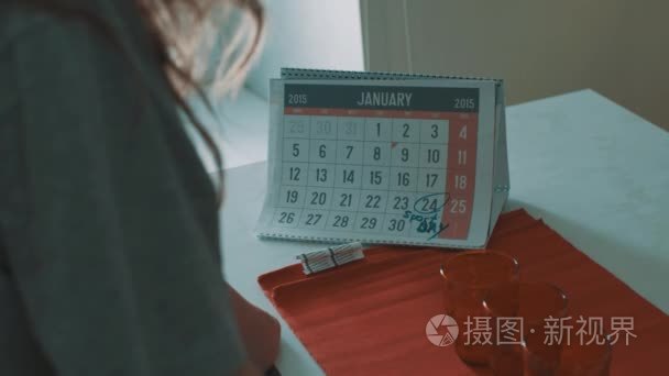 女人看着日历 2015 年 1 月，24 日期盘旋与马克运动日