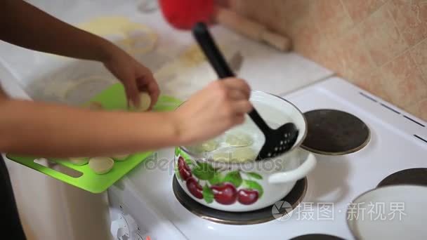 女孩煮在锅里的饺子。一个女孩准备的食物