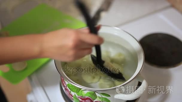 女孩煮在锅里的饺子。一个女孩准备的食物