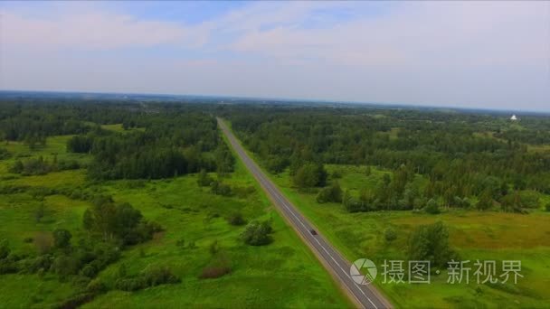 无人机飞行在高速公路中的绿色的森林