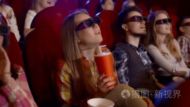 年轻人们观看电影，观看 3d，都笑了，吃着爆米花一出喜剧