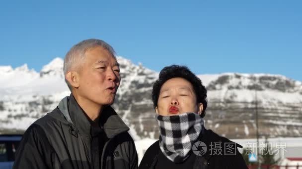 可爱的亚洲高级夫妇快乐蜜月结婚周年旅行在欧洲雪碱性磷酸酶。亲吻脸颊