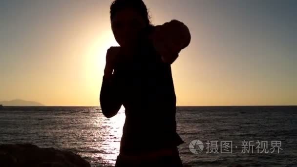 女子拳击在背景下的海上日出视频