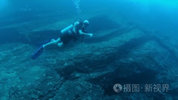 潜水员水下挂在岩石边