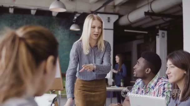 年轻的金发女子经理交谈混合的车队。女商人方向给现代办公的同事