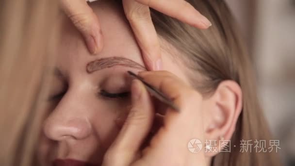 化妆师拔眉毛的女性客户端视频