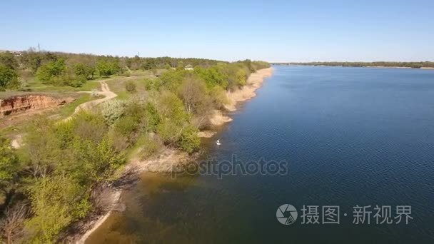 空中射击的 Dnipro 河波光粼粼的水域和其河岸与干藤