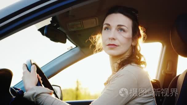 沉思和平静的中年妇女坐在一辆车。他钦佩性质从敞开的大门。温暖的晚上在日落之前视频