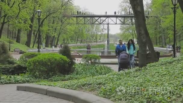 一对夫妇走在公园与童车及会谈视频