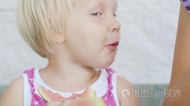 23 年酷蓝眼睛的女孩吃西瓜。农村的孩子，可爱的自制视频