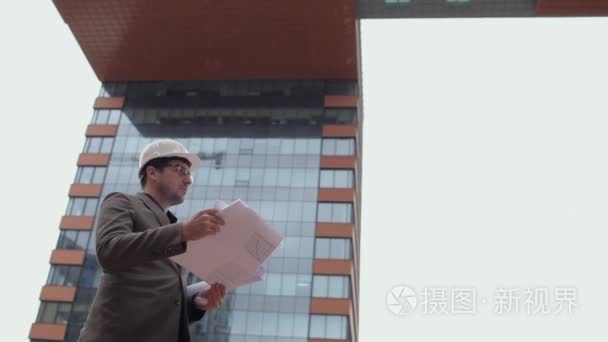 建筑师，商人看着图纸上的建筑背景