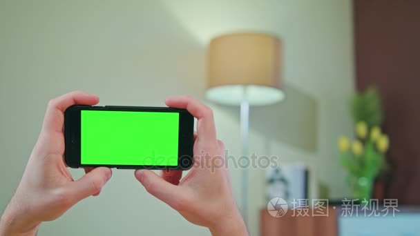 男手里拿着一款手机用绿屏视频