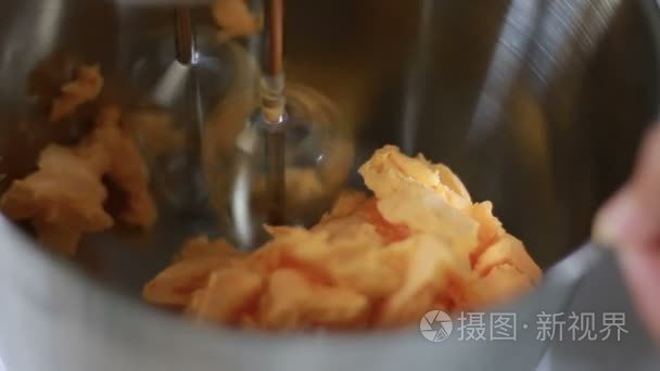 近摄镜头的不锈钢碗里的黄油与纺纱食品搅拌机