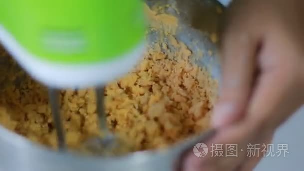 近摄镜头的不锈钢碗里的黄油与纺纱食品搅拌机