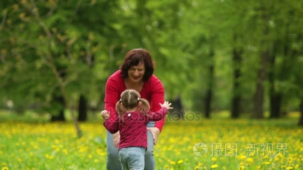 年轻的奶奶与她的三个孙子在公园散步。孩子们跑到奶奶，抱住她。连续性的几代人，家庭的爱，开心的周末，活跃老年生活视频