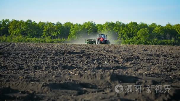 农民播种玉米种子在拖拉机上的字段