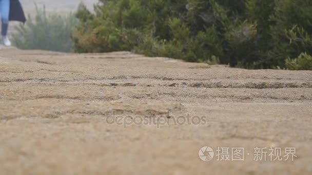 女性的脚石路上户外运行。慢跑在石头地上的美丽的大自然的女人的腿。假期旅行期间在山步进的女孩。健康积极的生活方式。慢动作