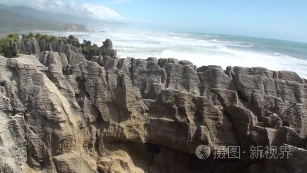 波浪对岩石的海岸和山新西兰视频