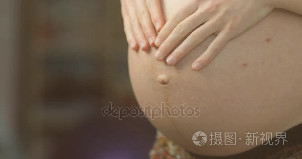 怀孕的女人显示肚皮视频