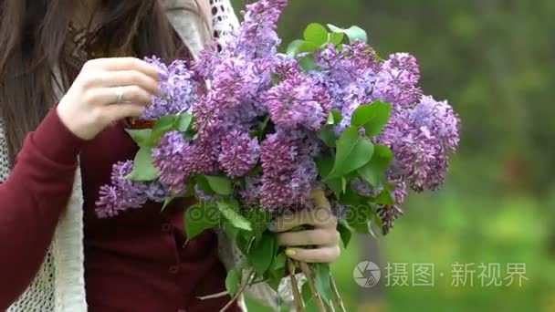 女人抱着一束丁香花，开花期