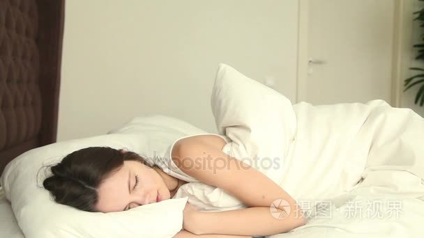 年轻的女子睡在不舒服的床上视频