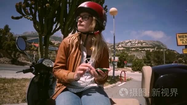 年轻女摩托车司机在电话上聊天视频