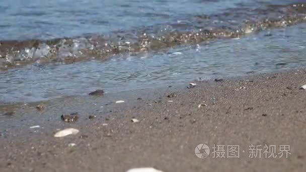 美丽小海浪拍打在沙滩上特写