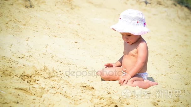 女孩坐在和在沙子中发挥
