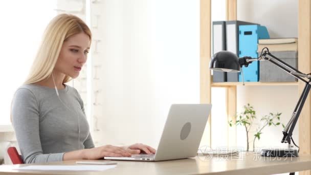视频聊天的创意办公室在笔记本电脑上的年轻女子