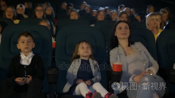 小女儿和朋友一起看在一家电影院看电影的女人