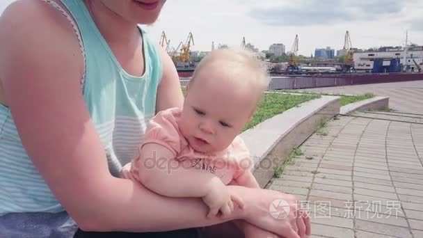 漂亮的宝宝坐在她母亲的膝盖上拍摄与无人机
