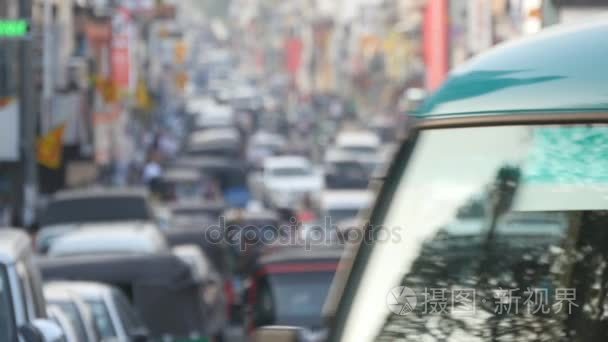 模糊无法辨认的人在逛市中心。汽车行驶在城市道路上。重点是背景的繁华的大城市交通繁忙