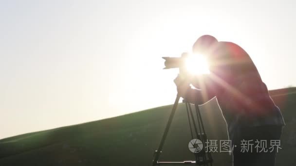 摄影师拍摄相机和三脚架山顶视频