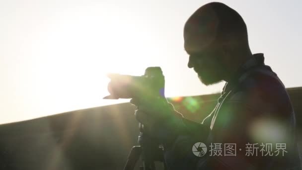 摄影师拍摄相机和三脚架山顶视频