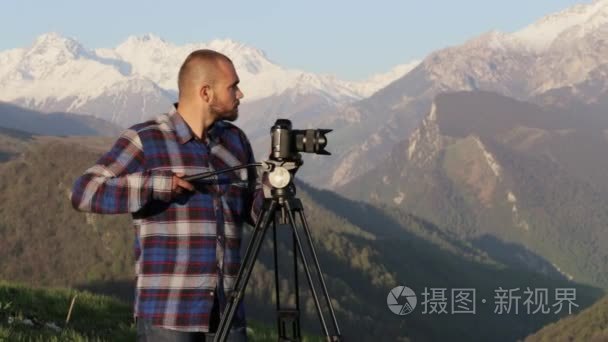 摄影师拍摄相机和三脚架山顶视频