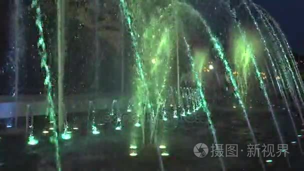 在市中心的晚上时间的喷泉。水然后上升再次它瀑布。底部的喷泉在不同颜色的灯光照耀视频