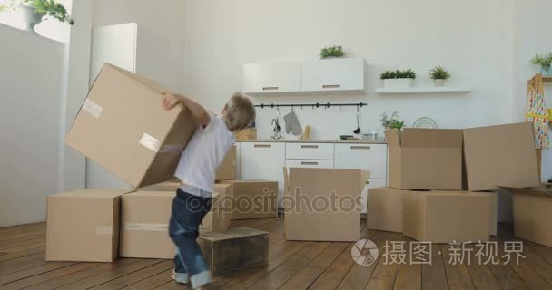 孩子帮助父母与移动到新的公寓，婴儿携带盒。移动到一个新的公寓概念