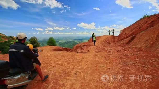 游客站在山坡的地面道路视频